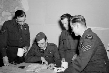 Three members of Goodfellow's crew share information from a raid with an officer at 434 Squadron. L to R (standing) are Jack Wheeler, Jerry Blanchard, Don Goodfellow.